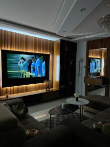 NgorにあるÉlégance appart Ngor 4eme étageの壁に薄型テレビが取り付けられたリビングルーム