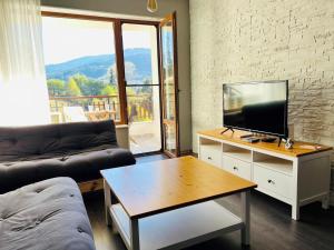a living room with a couch and a television on a table at Boris’s Guest Apartment in Chepelare