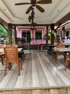 a patio with tables and chairs and a ceiling fan at ไข่มุกรีสอร์ทเกาะล้าน in Ko Larn +40 photos