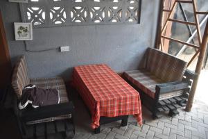 een kamer met 2 stoelen en een tafel met een deken bij Kituri Hostel in Dar es Salaam +13 foto's