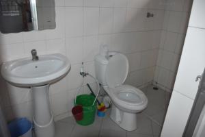 een kleine badkamer met toilet en wastafel bij Kituri Hostel in Dar es Salaam