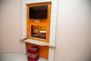 a room with a mirror and a tv on a wall at Résidence El Arich in Tozeur
