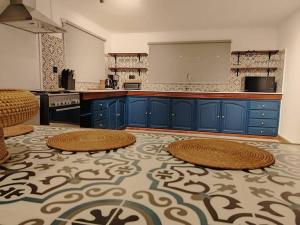 a large kitchen with blue cabinets and a large floor at Beach Hive in Blue Bay