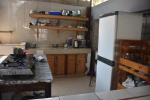 een keuken met een witte koelkast en een aanrecht bij Kituri Hostel in Dar es Salaam