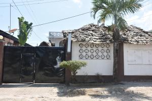 een poort voor een huis met een palmboom bij Kituri Hostel in Dar es Salaam