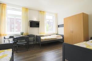 ハンブルクにあるBerne Apartmentsのテーブルとベッド1台付きの部屋、ダイニングルームが備わる客室です。