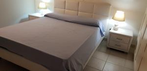 a bed in a room with two night stands and two lamps at Villa Kalos in Marinagri Resort in Policoro +86 photos