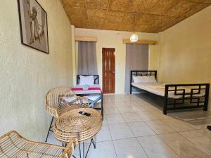 a room with two beds and a table and chairs at Acacia Sunset Village Inn in Dauis +39 photos