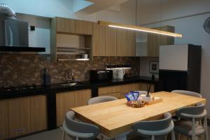 a kitchen with a wooden table and chairs at Domus in Kota Kinabalu