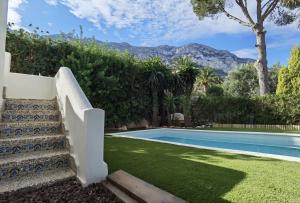 a house with a swimming pool and stairs next to a yard at Casa Agave in Denia