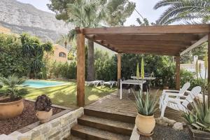 a patio with a table and chairs next to a pool at Casa Agave in Denia +12 photos