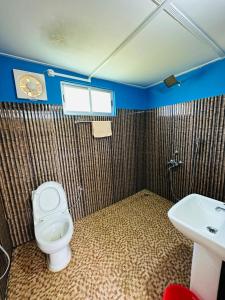 un baño con inodoro y lavabo en TULDA BAMBUSA RESORT, en Kāziranga 96 fotos más