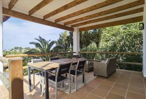 a wooden table and chairs on a patio with a pergola at Casa Agave in Denia