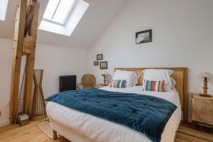 a bedroom with a bed with a blue blanket on it at Le Domaine de Courances - Pierres d'Histoire in Courances