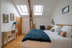 a bedroom with a large bed and two skylights at Le Domaine de Courances - Pierres d'Histoire in Courances
