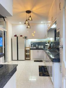a kitchen with white cabinets and black counter tops at Breeyana's Private Resort in Biñan