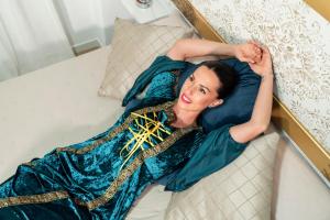 a woman in a blue dress laying on a bed at Apartamento El Oso y el Madroño II Thematic in Villena