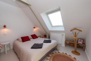 a bedroom with a bed with red pillows on it at Les Palissades - La mer du bon côté in Saint-Pierre-Quiberon +32 photos