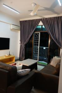 a living room with a couch and a table and a window at Domus in Kota Kinabalu