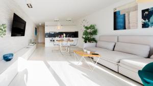 a white living room with a white couch and a table at VacationClub - Bukowa 17A Apartament G6 in Tokarnia