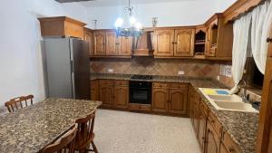 a kitchen with wooden cabinets and a refrigerator at Private Room in San Ġwann