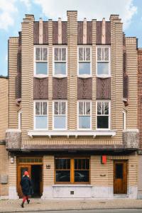 a person walking in front of a large building at Huis Hector Mechiels HOUSE in Lindeken