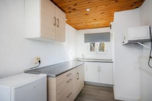 坎帕斯蒂利亚Mallorca Rooms Can Pastilla的一间厨房,配有白色家电和木制天花板