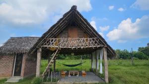 a small house with a hammock and a net at Cosmorama in Auroville