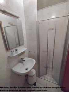 a bathroom with a toilet and a sink and a shower at Pension Villa Brödel in Bad Blankenburg