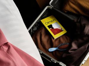 a suitcase with a book and a brush in it at Mekano Apartment Hotel in Copenhagen