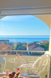 un tavolo con vista sull'oceano da un balcone. di La Sirène - Loft moderne et lumineux avec vue panoramique sur Mer Méditerranée et port de plaisance a Frontignan