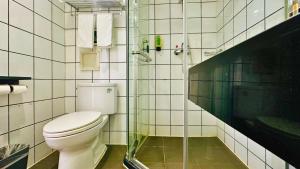 a bathroom with a toilet and a glass shower at Shanghai Zhongan Hotel Xizang North Road Subway Station Branch in Shanghai +20 photos