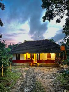 a house with a dirt road in front of it at TauSco Homestay & Campsite - Coorg in Madikeri