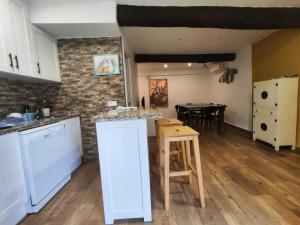 a kitchen with a counter and a table in a room at Solaz del Ambroz Hervas 1 in Hervás