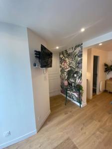 een woonkamer met een harde houten vloer en een muur bij la maison d' antoine 2 in Chamalières