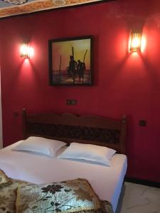 a bedroom with two beds and a red wall at My Guest Mirissa in Mirissa