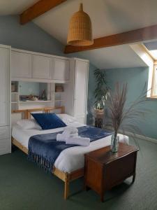 ein Schlafzimmer mit einem großen Bett und einem Tisch in der Unterkunft Maison spacieuse proche Nantes 7 personnes in Sainte-Luce-sur-Loire