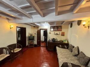a living room with chairs and a table and a television at TauSco Homestay & Campsite - Coorg in Madikeri
