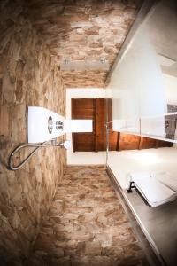 a bathroom with a stone wall at Domu Virginia in Castiadas