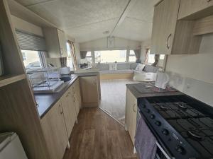 a kitchen with a stove and a sink and a stove at Ruby a modern caravan in Rhyl in Rhyl