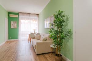 a living room with a couch and a plant at Valentino Apartment by Toh Solution in Turin +61 photos