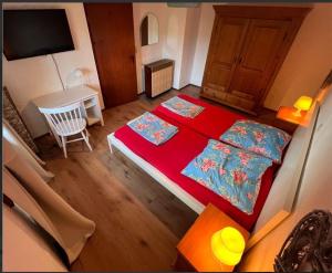 Un dormitorio con dos camas y una mesa y un televisor. en Ferienwohnung am Bach Biberstüble, en Tengen