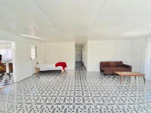 ein Wohnzimmer mit einer Couch und einer Couch in der Unterkunft Private Double Room - Airport Cottage in Fua‘amotu + 1 Foto