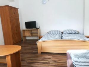 a bedroom with a bed and a desk with a television at LEVNÉ UBYTOVÁNÍ Ústí nad Labem in Ústí nad Labem