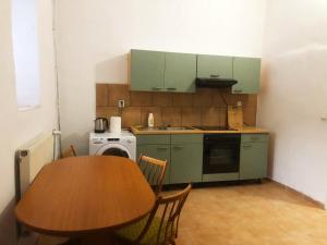 a small kitchen with a wooden table and a table and chairs at LEVNÉ UBYTOVÁNÍ Ústí nad Labem in Ústí nad Labem