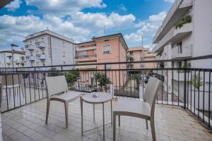 balkon ze stołem, krzesłami i budynkami w obiekcie SOMA w Rimini