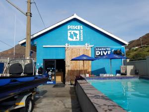 a blue building with a swimming pool in front of it at Two Penguins in Cape Town