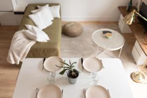 un salon avec une table blanche et un canapé dans l'établissement La forêt Suspendue - T2 douillet avec Parking Gratuit, à Toulouse
