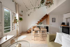 une cuisine et un salon avec une table et des chaises dans l'établissement La forêt Suspendue - T2 douillet avec Parking Gratuit, à Toulouse