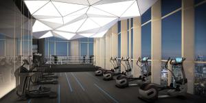a gym with treadmills and ellipticals in a building at 1BR l 10 Mins from Siam Paragon l Rooftop Pool in Bangkok